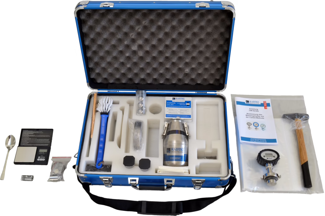 WOLFF_Dummy_84546_CCM-instrument Alu Business Pro_2025-08 Open blue carrying case with foam inserts holding a moisture measurement kit. Visible items include a metal sample container labeled 'RADTKE MESSTECHNIK', a long-handled brush, a small digital scale with a spoon, a manual, a pressure/gauge instrument, a wooden-handled hammer, batteries, small sealed accessories and several black protective caps, all neatly arranged in cut foam compartments.