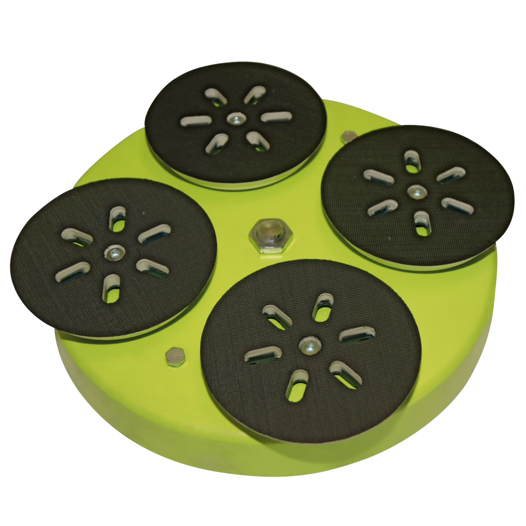 Vue rapprochée en plongée d'un outil circulaire vert citron à plusieurs plateaux avec cinq patins ronds noirs pour poncer ou polir, disposés en motif floral sur un fond blanc. Chaque patin présente des fentes découpées et une surface en caoutchouc texturée ; des vis, boulons et un écrou central en métal maintiennent les patins sur la base métallique verte. L'image met en valeur la texture des patins, les ouvertures fendues et le contraste entre les faces noires et le corps métallique vert vif.