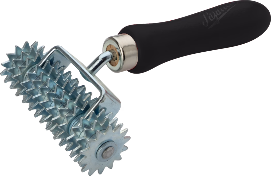 Gros plan d'un rouleau métallique à pointes composé de plusieurs roues étoilées s'emboîtant et d'une poignée ergonomique noire. Les rouleaux en acier galvanisé présentent des dents tranchantes et régulièrement espacées réparties sur plusieurs petites roues tournant sur un axe ; ils sont montés dans un châssis chromé robuste relié à une tige métallique courbée et une poignée en plastique noir rembourrée. L'outil, photographié sur fond blanc, sert à presser des coutures, à rugosifier des surfaces, à créer des textures ou à améliorer l'adhérence pour des revêtements de sol, la pose de papiers peints, la maroquinerie ou des travaux d'artisanat.