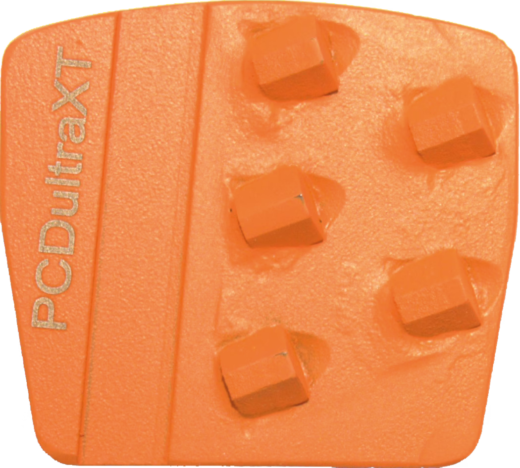 WOLFF_Dummy_75365_PCD ultra XT orange_2025-08 Gros plan d'un segment de meulage ou de polissage orange en forme de trapèze, avec cinq pastilles abrasives carrées disposées sur sa surface, une base texturée et une bande verticale surélevée à gauche estampillée 'PCDultraXT'. L'outil présente de légères traces d'usure et sert à la préparation de surfaces en béton ou en pierre.